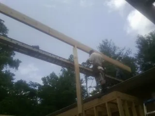 Carpenter setting a ridge beam over a new addition frame — Ice Dam Removal by Roofing Brothers in Hockley