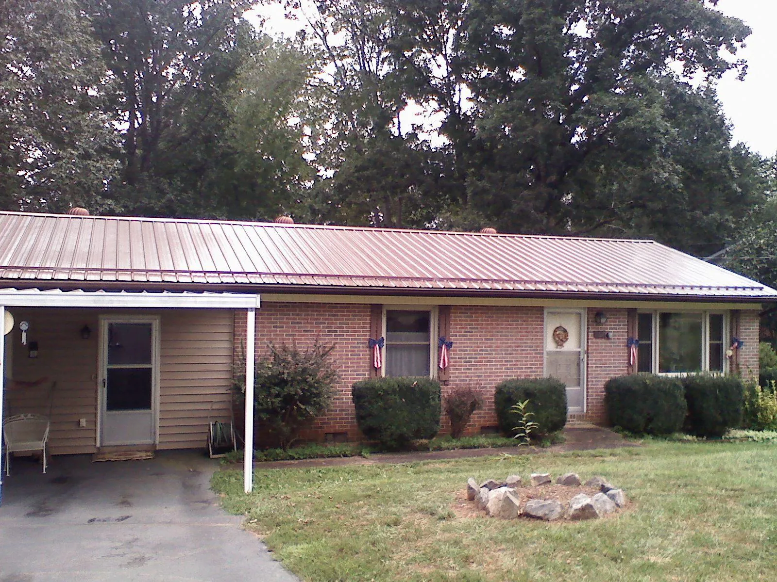 Bronze metal roof and carport on a brick ranch home — Roof Repair work by our crew in Hockley